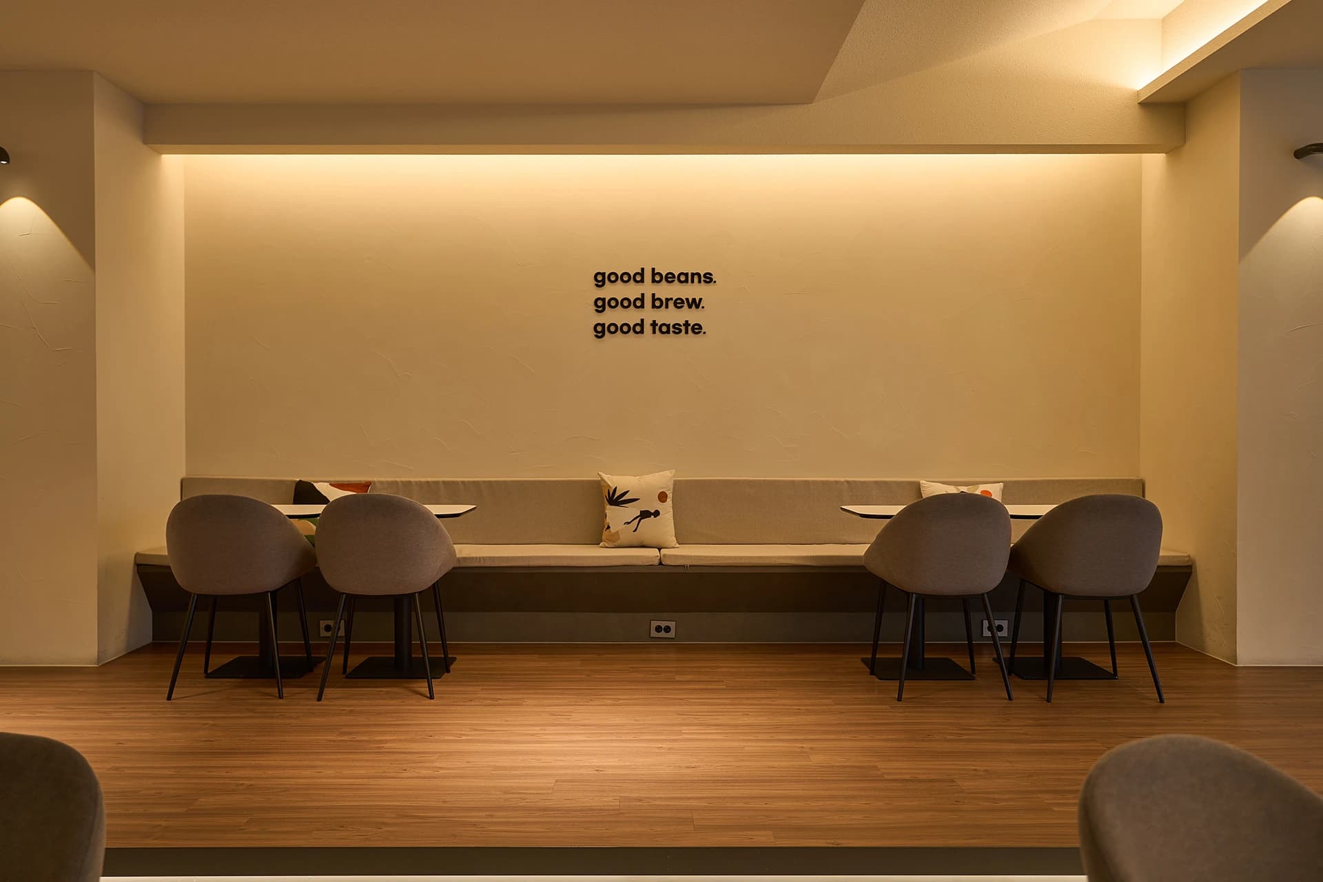 「good beans. good brew. good taste.」 문구가 걸린 굳띵즈 매장 좌석
